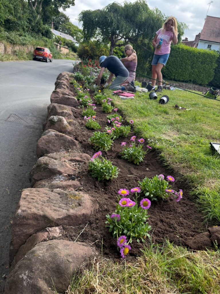 Three ladies planting flowers in the border at GVH
