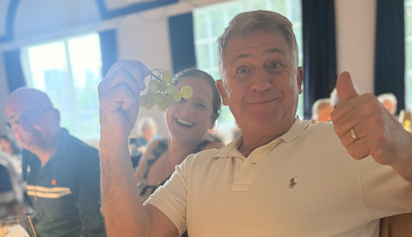 Man holding up a bunch of grapes.